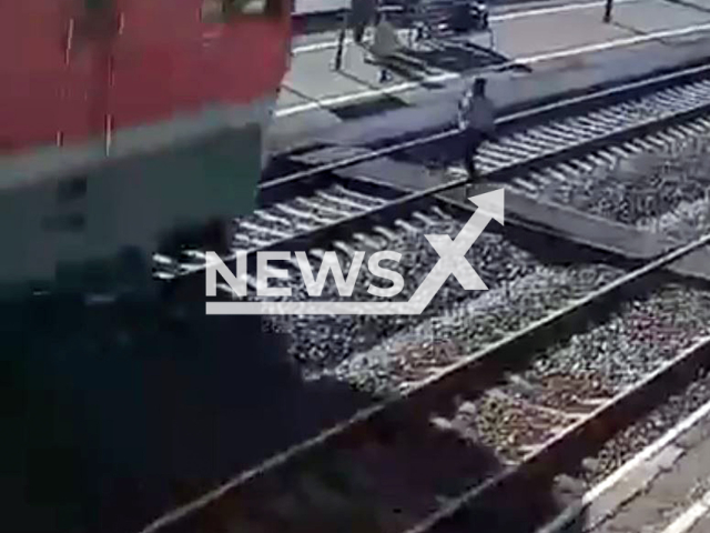 This image is a screen grab of the video supplied titled NewsX-TrainStruck-01.mp4: CCTV shows a 21-year-old student, wearing headphones and unaware of an oncoming train, was fatally struck while crossing the tracks in Omsk, Russia on Monday, May 5, 2025.(Clipzilla/NX)