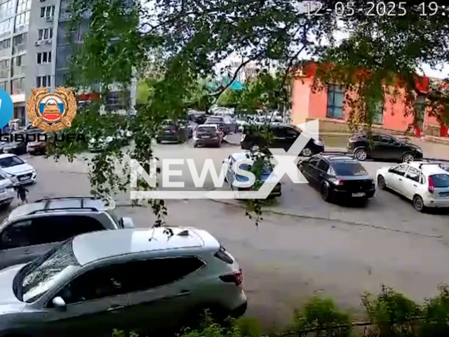 This image is a screen grab of the video supplied titled NewsX-UnderSlip-01.mp4: Footage shows a 4-year-old running and slipping under a car in Ufa, Russia on Monday, May 12, 2025.(Clipzilla/NX)