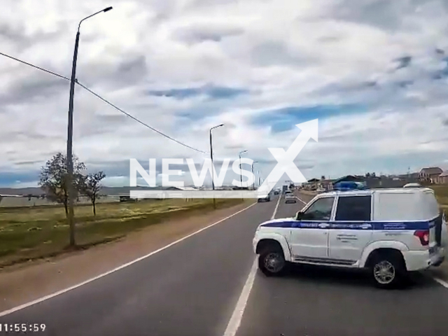 This image is a screen grab of the video supplied titled NewsX-TurnCrash-01.mp4: Dashcam footage shows a police UAZ Patriot attempting a sudden U-turn from the roadside and colliding with a KamAZ truck traveling in the same direction in Kumtorkalinsky District, Republic of Dagestan, Russia on Wednesday, May 14, 2025. (Clipzilla/NX)