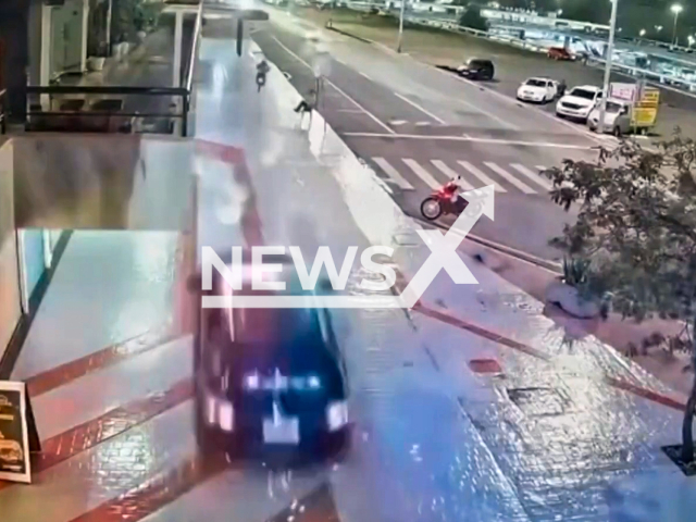 This image is a screen grab of the video supplied titled NewsX-CheisPolice-01.mp4: CCTV shows a police car and motorcycle on a high-speed chase on a sidewalk in Asa Sul, Brasilia, in Brazil on the 12th of April, 2025.(Clipzilla/NX)