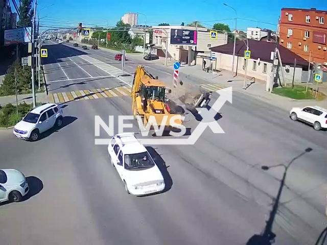 This image is a screen grab of the video supplied titled NewsX-TractorFlip-01.mp4: CCTV footage shows a Caterpillar tractor abruptly swerving to avoid a Lada, sideswiping a Nissan Qashqai which overturned into oncoming traffic and collided with a VW Tiguan — the tractor then crashed into a parked Skoda Rapid at the intersection n Volgograd, Russia on Monday, May 12, 2025. (Clipzilla/NX)