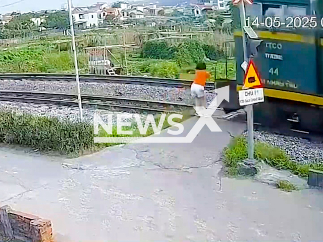 This image is a screen grab of the video supplied titled NewsX-VietTrein-01.mp4: CCTV footage shows a woman being hit by a train in Cam Pha City, Quang Ninh Province, Vietnam on Wednesday, May 14, 2025.(Clipzilla/NX)
