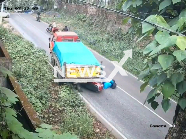 This image is a screen grab of the video supplied titled NewsX-RollBack-01.mp4: CCTV footage shows a woman narrowly escaping death after a truck suddenly rolled backward and crushed her scooter on the Peringalam-Kozhikode road, Kerala, India on Thursday, May 15, 2025.