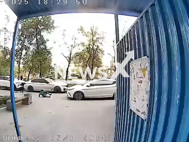 This image is a screen grab of the video supplied titled NewsX-BoyHit-01.mp4: CCTV shows a child unexpectedly rolling out onto the roadway from the sidewalk and being hit by a car in Novosibirsk, Russia on Wednesday, May 14, 2025.(Clipzilla/NX)