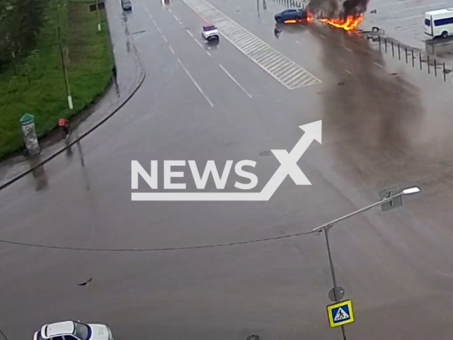 This image is a screen grab of the video supplied titled NewsX-DriverFlame-01.mp4: CCTV footage shows a drunk driver losing control during a left turn, crashing into a guardrail and causing the car to burst into flames — the driver escaped with burn injuries in Magnitogorsk, Russia on Tuesday, May 20, 2025.(Clipzilla/NX)