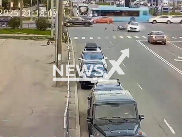 This image is a screen grab of the video supplied titled NewsX-PoliceCarCollision-01.mp4: Dashcam footage shows a motorcyclist colliding with a police patrol car with flashing lights at the intersection of Khasanskaya Street and Industrialny Prospekt in the Krasnogvardeisky District in Saint Petersburg, Russia on Sunday, May 18, 2025.(Clipzilla/NX)