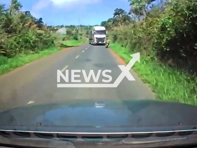 This image is a screen grab of the video supplied titled NewsX-VietJungle-01.mp4: Dashcam shows a container truck losing control and swerving into the opposite lane, hitting a motorbike and a car, killing two people on the spot on Highway 28, Dak Nong, Vietnam on Thursday, May 15, 2025.(Clipzilla/NX)