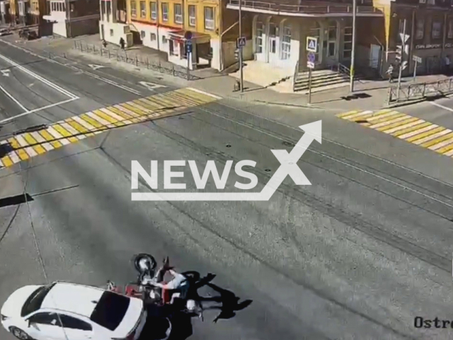 This image is a screen grab of the video supplied titled NewsX-KiaColli-01.mp4: CCTV shows a motorcyclist crashing into a car turning left on a green light at the intersection of Ostrovsky and Aidinov streets in Kazan, Russia on Monday, May 19, 2025.(Clipzilla/NX)