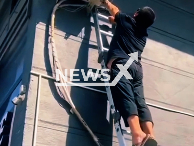 This image is a screen grab of the video supplied titled NewsX-ManElectricShock-01.mp4: Footage shows a worker getting electrocuted while repairing an air conditioner in Kyrgyzstan, undated. Footage shared on Facebook on Thursday, May 23, 2025.(Clipzilla/NX)
