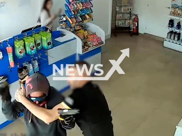This image is a screen grab of the video supplied titled NewsX-RobersBusted-01.mp4: Footage shows a masked man trying to rob the gas station, but an employee pepper-sprayed him, and after a struggle, the suspect fled without the loot in Aguilas, Murcia, Spain, undated. The suspect was arrested three days later by the Civil Guard.(Clipzilla/NX)