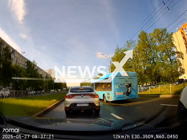 This image is a screen grab of the video supplied titled NewsX-BusSurfer-01.mp4: Footage shows a young boy climbing onto the back of the bus, trying to get free transport at Artists Avenue in Saint Petersburg, Russia on Tuesday, May 27, 2025.(Clipzilla/NX)