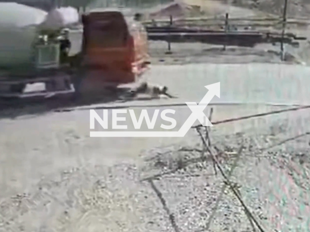 This image is a screen grab of the video supplied titled NewsX-ConstructionSite-01.mp4: CCTV shows a KamAZ driver fatally striking a 45-year-old woman in Amur Oblast, Russia on Monday, May 26, 2025. (Clipzilla/NX)