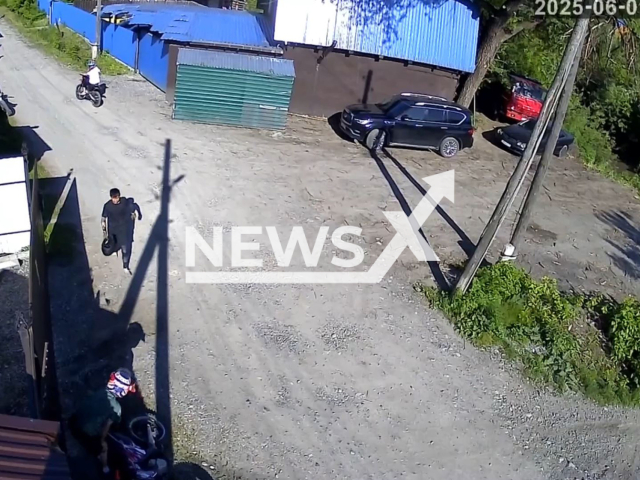 This image is a screen grab of the video supplied titled NewsX-FenceCrash-01.mp4: CCTV shows a motorcyclist crashing into a fence and fleeing in Gorno-Altaisk, Altai Republic, Russia on Sunday, June 1, 2025.(Clipzilla/NX)