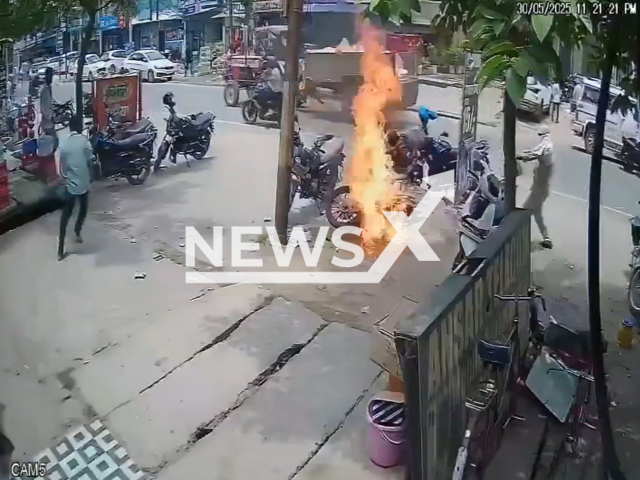 This image is a screen grab of the video supplied titled NewsX-TwoWheelerFlames-01.mp4: CCTV camera shows a man narrowly escaping as two two-wheeler bursts into flames while starting in Basti district, Uttar Pradesh, India on Friday, May 30, 2025.(Clipzilla/NX)