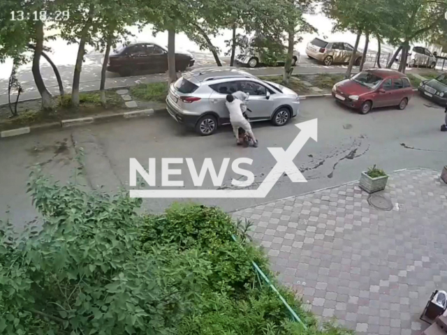 This image is a screen grab of the video supplied titled NewsX-SharedElecScooter-01.mp4: CCTV footage shows two schoolchildren riding on the same scooter crashing into a car parked in the yard and fleeing the scene in Omsk, Russia on Saturday, May 31, 2025.(Clipzilla/NX)