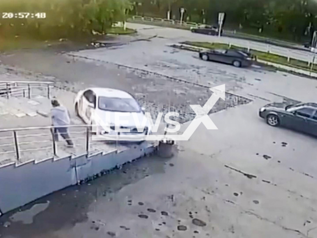 This image is a screen grab of the video supplied titled NewsX-IntoxicatedTaxi-01.mp4: CCTV footage shows a drunk driver crashing a taxi into a staircase and railing in Korkino, Chelyabinsk Oblast, Russia on Monday, June 23, 2025.