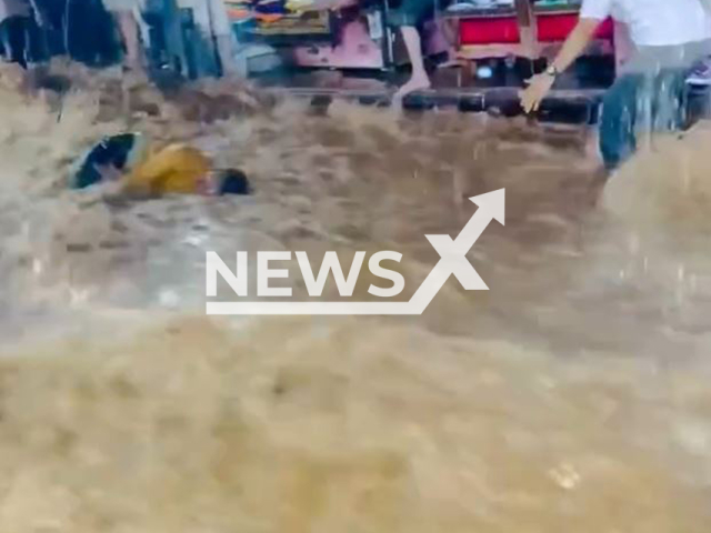 Floodwater sweeps away a man in Ajmer, India, undated. He was saved by a hotel worker. Note: Photo is a screenshot from a video(Newsflash/NX)