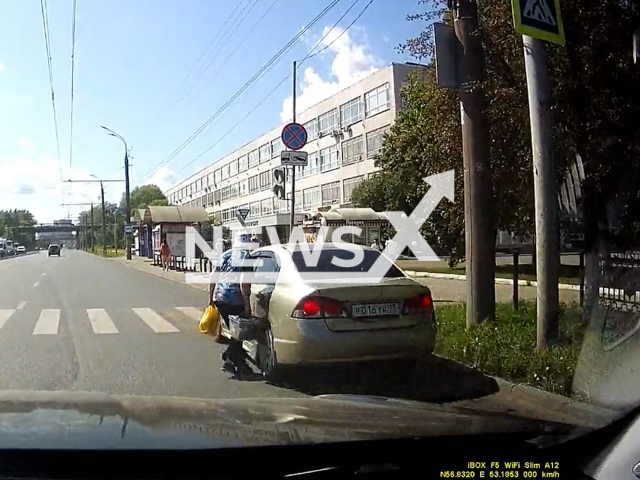 This image is a screen grab of the video supplied titled NewsX-SpeedElderly-01.mp4: Dashcam shows elderly woman narrowly escapes being hit by a car on zebra crossing in Izhevsk, Russia on Thursday, July 17, 2025. (Clipzilla/NX)