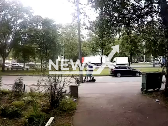 This image is a screen grab of the video supplied titled NewsX-PoleScooter-01.mp4: CCTV footage shows a scooter riding on the sidewalk, with two people riding it, crashing into a pole, and both falling to the ground in the Frunzensky District of St. Petersburg, Russia on Thursday, July 31, 2025.(Clipzilla/NX)