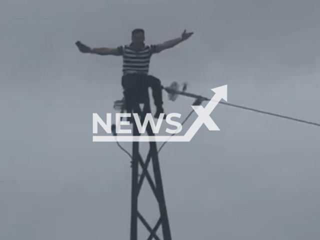 This image is a screen grab of the video supplied titled NewsX-PowerLine-01.mp4: Footage shows man climbed to the very top of the support of the power line in Volchanets, in the Partizansky District of Primorsky Krai, Russia on Tuesday, July 29, 2025.(Clipzilla/NX)