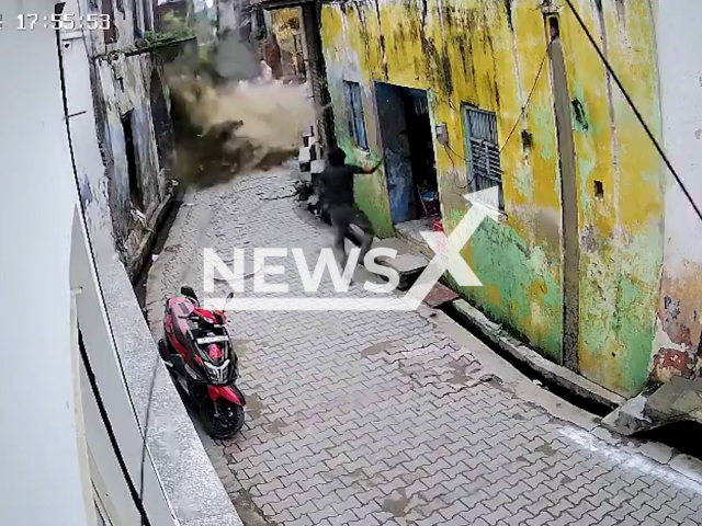 This image is a screen grab of the video supplied titled NewsX-SchoolBuild-01.mp4: CCTV footage shows a woman narrowly escaping as an old government school building collapses in Hapur, Uttar Pradesh, India on Monday, August 4, 2025.( Clipzilla/NX)
