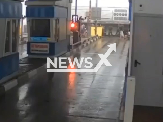 This image is a screen grab of the video supplied titled NewsX-BusToll-01.mp4: CCTV footage shows a bus crashing into the support structure of a toll collection point and tipping over the M-4 'Don' highway in the Tula region, Russia on Tuesday, August 5, 2025.(Clipzilla/NX)
