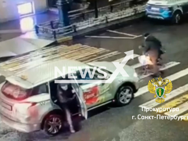 This image is a screen grab of the video supplied titled NewsX-CrossRider-01.mp4: Footage shows a 42-year-old man firing an aerosol pistol at a scooter rider who blocked car's path in Saint Petersburg, Russia, on December 3, 2024. The Saint Petersburg Prosecutor's Office has opened a criminal case against the man for 'hooliganism committed with the use of violence.(Clipzilla/NX)