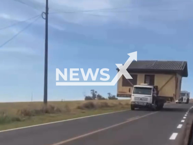 This image is a screen grab of the video supplied titled NewsX-TruckHuse-01.mp4: Footage shows truck transporting the wooden house on a highway in Parana, Brazil on Saturday, Aug 2. 2025.(Clipzilla/NX)