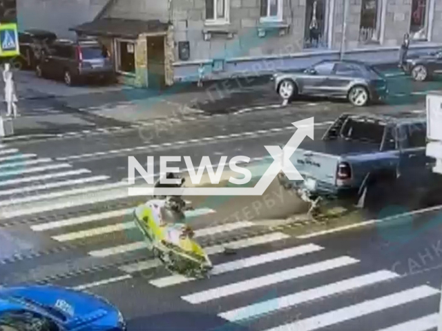 This image is a screen grab of the video supplied titled NewsX-PickupTraffic -01.mp4: CCTV shows a tram crashing into a pickup truck carrying a jet ski and watercraft on a trailer causing them to fall onto the road and hit a nearby parked car on Savushkina Street, Saint Petersburg, Russia on Sunday, Aug 10, 2025.