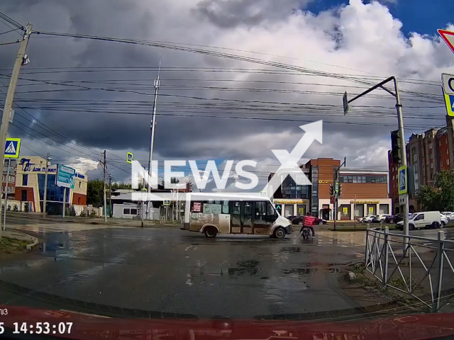 This image is a screen grab of the video supplied titled NewsX-DeliveroHit-01.mp4: Footage shows  a courier crossing  the road on a red light and being hit by a minibus in Omsk, Russia on Saturday, Aug 9, 2025.(Clipzilla/NX)