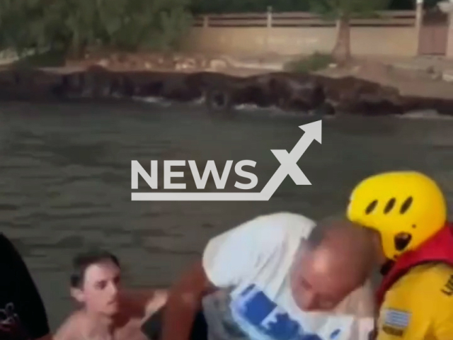 This image is a screen grab of the video supplied titled NewsX-GreekFlames-01.mp4: Video shows Hellenic Red Cross volunteers rescuing people from the water in Vrachneika in Achaea, Greece on Wednesday, Aug 13, 2025.(@greekredcrossofficial/Clipzilla/NX)