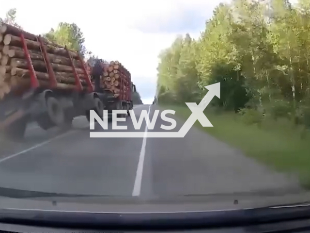 This image is a screen grab of the video supplied titled NewsX-LogJam-01.mp4: Footage shows a truck overtaking a passenger car, after which the truck driver does not follow the trajectory of movement, and the trailer falls on its side, causing logs to fall onto the roadway in Sverdlovsk Oblast, Russia on Friday, Aug 8, 2025.(Clipzilla/NX)