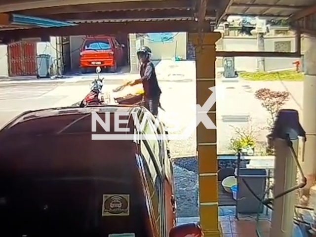 This image is a screen grab of the video supplied titled NewsX-BikerSet-01.mp4: CCTV shows a man nearly burned to death when his motorcycle caught fire after he allegedly set two cars ablaze at a house in Bukit Katil in Melaka, Malaysia on Saturday, Aug 23, 2025.(Clipzilla/NX)