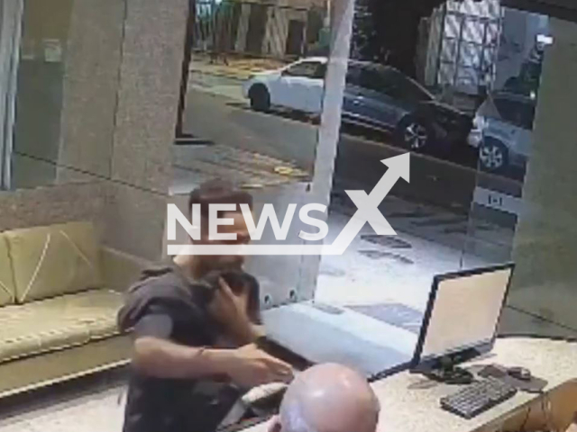 This image is a screen grab of the video supplied titled NewsX-ThiefClumsy-01.mp4: CCTV shows a clumsy armed thief robbing a hotel fumbling with his coat and cap as his face is repeatedly exposed before fleeing on foot with the cash in Copacabana, Rio de Janeiro, Brazil on Thursday, Aug 21, 2025.(Clipzilla/NX)