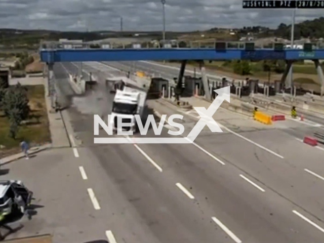 This image is a screen grab of the video supplied titled NewsX-TollCrashCops-01.mp4: Footage shows truck crashes into the tool barriers and then crashed into parked police vehicle sending it into a dich in Cekmekoy, Istanbul, Turkey on Thursday, Aug 28, 2025.(Clipzilla/NX)