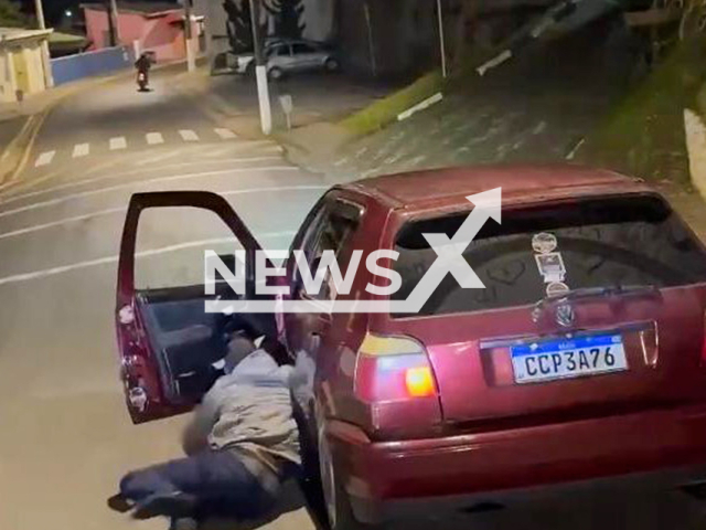 This image is a screen grab of the video supplied titled NewsX-RooDrive-01.mp4: Footage shows a driver climbing onto the roof of his moving car before falling, as the out-of-control vehicle crashes into a house in Cajati, Sao Paulo, on Saturday, Aug 30, 2025.(Clipzilla/NX)