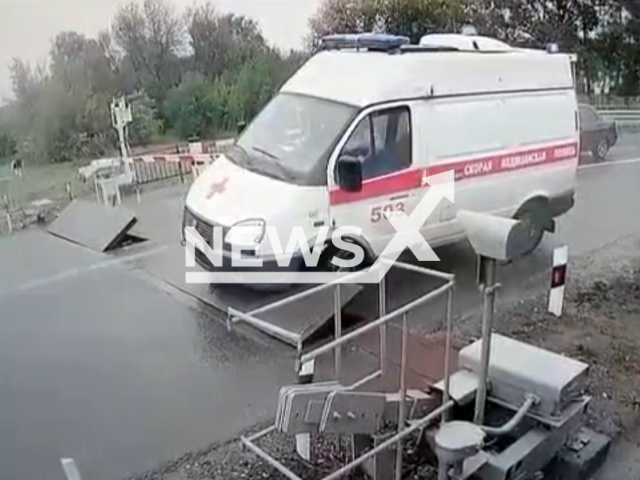 This image is a screen grab of the video supplied titled NewsX-AmbuTrap-01.mp4: Footage shows an ambulance crashing into a railroad crossing barrier and the driver forcefully attempting to cross again in Shuya, Ivanovo region of Russia on Tuesday, Sep. 2, 2025.(Clipzilla/NX)