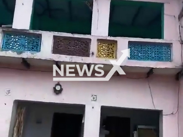 Woman jumps from roof of a house in Aligarh, India, undated. She suffered injuries. Note: Photo is a screenshot from a video. (Newsflash/NX)