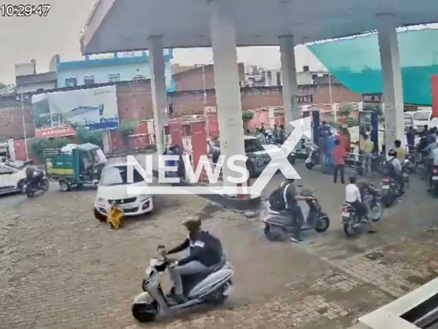 This image is a screen grab of the video supplied titled NewsX-WomenDown-01.mp4: Footage shows woman sitting at a petrol pump being crushed by a car in Agra, Uttar Pradesh, India on Wednesday, Sep. 3, 2025.(Clipzilla/NX)