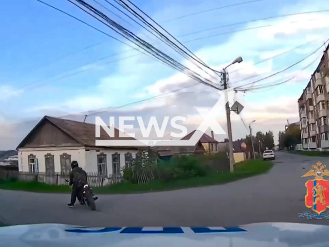 This image is a screen grab of the video supplied titled NewsX-BikerGarage-01.mp4: A drunk motorcyclist  crashes into a garage while fleeing police, revealing a high level of intoxication during roadside testing in in Achinsk, Krasnoyarsk Krai, Russia on Wednesday, Sep. 3, 2025.(Clipzilla/NX)
