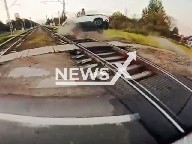 This image is a screen grab of the video supplied titled NewsX-RailwayCrossing-01.mp4: Footage shows a car losing control and overturning  on the rails in Pushkin, Saint Petersburg, Russia on Tuesday, Sep. 9, 2025.(Clipzilla/NX)