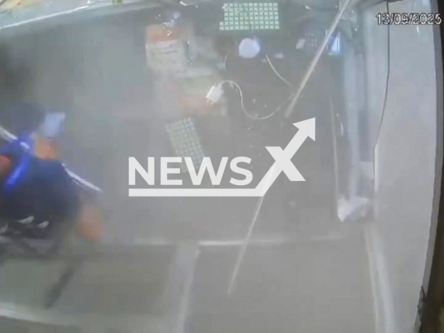 This image is a screen grab of the video supplied titled NewsX-PlazaTyre-01.mp4: CCTV footage a truck’s tyre suddenly burst like a bomb while passing through, shattering the toll booth glass and injuring an employee, who narrowly escaped a more serious accident in Hingonia toll plaza in Jaipur, India on Saturday, Sep. 13. 2025.(Clipzilla/NX)