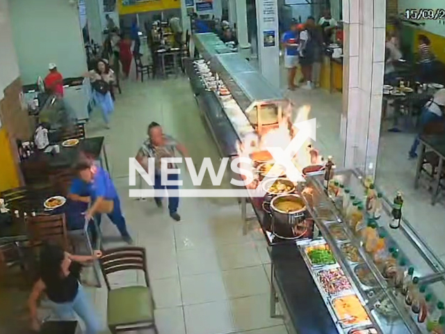 This image is a screen grab of the video supplied titled NewsX-StoreFoodys-01.mp4: CCTV shows a restaurant employee lighting a pot of alcohol that exploded, engulfing her in flames, injuring customers in the ensuing stampede, before the fire was contained with an extinguisher in Mar Grande, Vera Cruz, Bahia, Brazil on Monday, Sep. 15, 2025.(Clipzilla/NX)