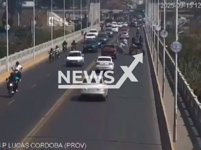 This image is a screen grab of the video supplied titled NewsX-BikeHorses-01.mp4: CCTV shows a couple riding a motorcycle with their son crash into a horse-drawn cart throwing them into the opposite lane where they were hit by a pickup truck before falling under a car, surviving with injuries on the Lucas Cordoba bridge in Banda del Rio Sali , Tucuman Province , Argentina on Monday, Sep. 15, 2025.(Clipzilla/NX)