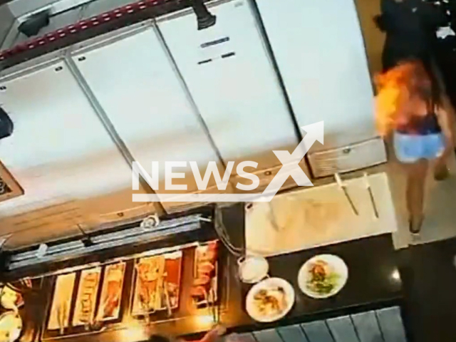 This image is a screen grab of the video supplied titled NewsX-HunSet-01.mp4: Footage shows a woman  suddenly engulfed in flames after a worker refilled a stove with alcohol gel, leaving her with serious burns at the Varanda 1389 restaurant in Belo Horizonte, Brazil on Sunday, Sep. 21, 2025.( Clipzilla/NX)