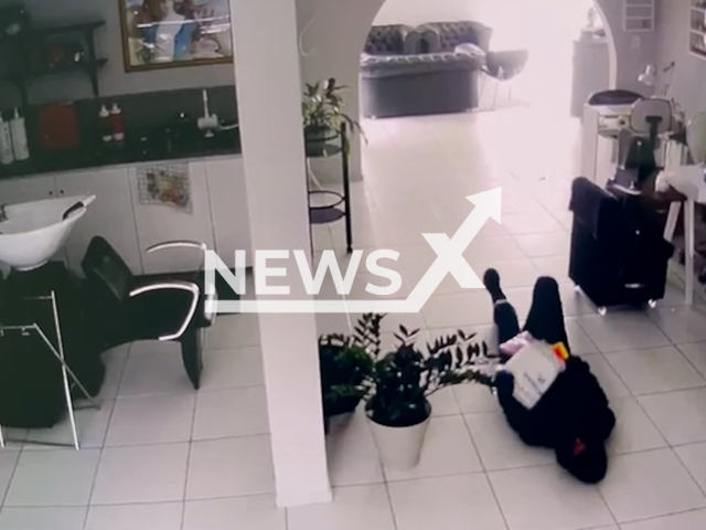 This image is a screen grab of the video supplied titled NewsX-NinjesRobers-01.mp4: Security footage shows a suspect crawling 'ninja-style' through a store with his body fully covered in a attempt to avoid identification in Santa Monica neighborhood , in Florianopolis, Brazil on Sunday, Sep. 21, 2025.(Clipzilla/NX)
