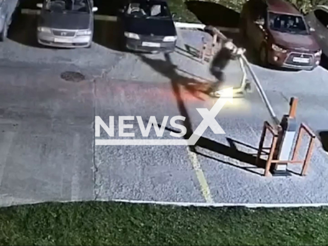This image is a screen grab of the video supplied titled NewsX-BarrierStunt-01.mp4: Footage shows electric scooter rider crashing into a barrier in a courtyard in Vladivostok, Russia, undated. Footage shared on telegram on Tuesday, Sep. 23, 2025.(Clipzilla/NX)