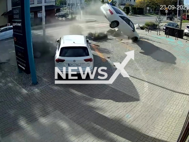 This image is a screen grab of the video supplied titled NewsX-PolFly-01.mp4: Surveillance footage captures a car flying through the air and crashing into a utility pole in a spectacular, Hollywood-style stunt-gone-wrong in Wroclaw's Wojnow neighborhood, Poland on Monday, Sep. 23, 2025.(Clipzilla/NX)