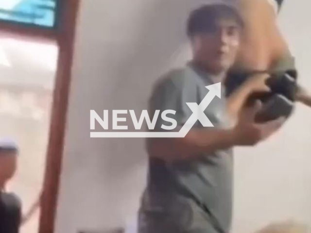 A thief gets stuck in the window in Jakarta, Indonesia, undated. He begged for help. Note: Photo is a screenshot from a video (Newsflash/NX)