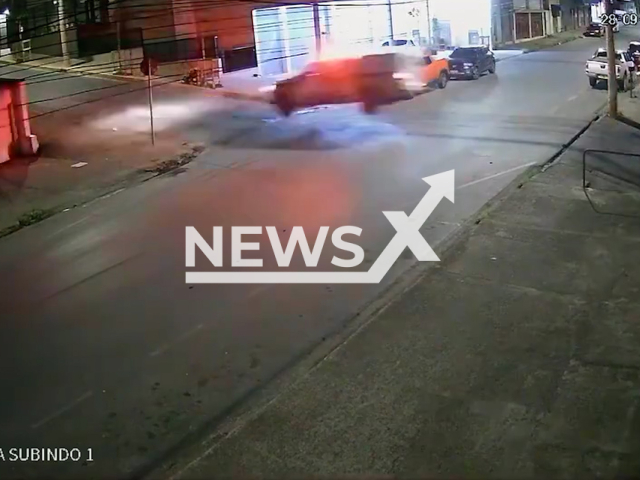 This image is a screen grab of the video supplied titled NewsX-CopsFly-01.mp4: CCTV footage shows chase where a stolen car and a Military Police patrol vehicle appear to “fly” over a bump as they speed through the streets in Barreiro, Belo Horizonte, Brazil on Sunday, Sep. 28, 2025.(Clipzilla/NX)